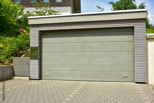 Moderne Beton-Garage mit Automatik-Tor in der Hauszufahrt