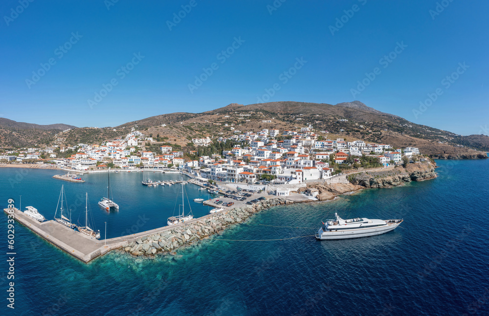 Andros island Batsi village Cyclades Greece. Aerial drone view of port, breakwater yacht, sea sky.
