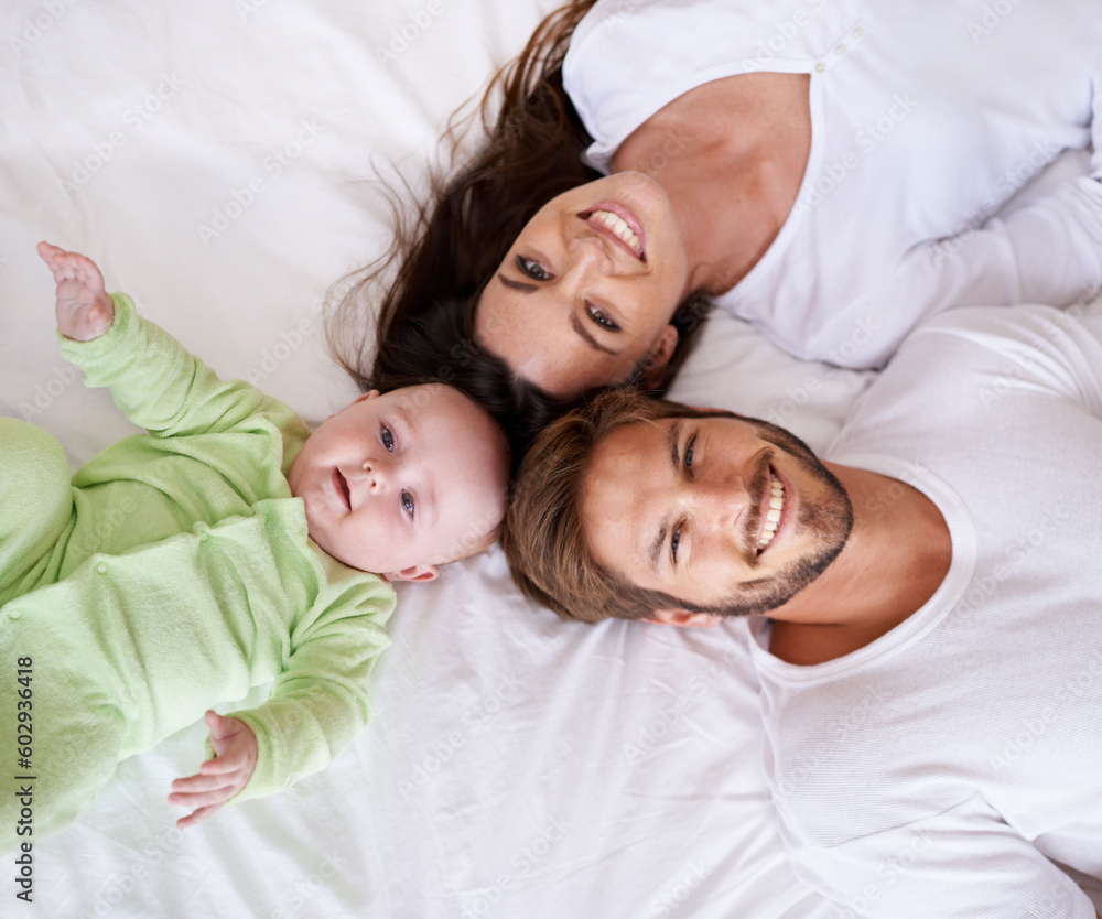 Top view portrait of mother, father and baby on bed for love, care and quality time together at home. Happy parents, family and cute newborn kid relax in bedroom with smile, support and fun bonding Top view portrait of mother, father and baby on bed for love, care and quality time together at home. Happy parents, family and cute newborn kid relax in bedroom with smile, support and fun bonding