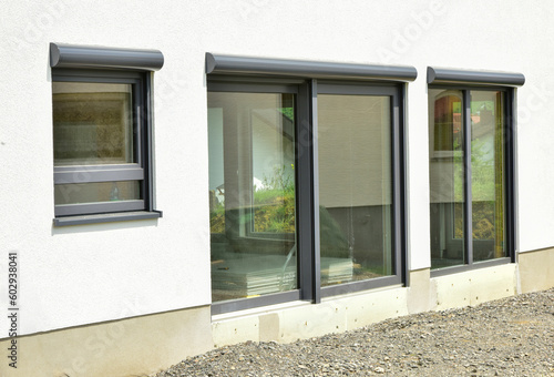 Moderne Fenster in einer gemauerten, verputzten und gestrichenen Fassade eines modernen Wohnhauses