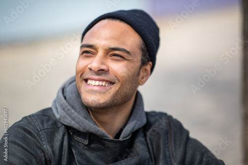 Cheerful young african man in winter wear looking away and smiling