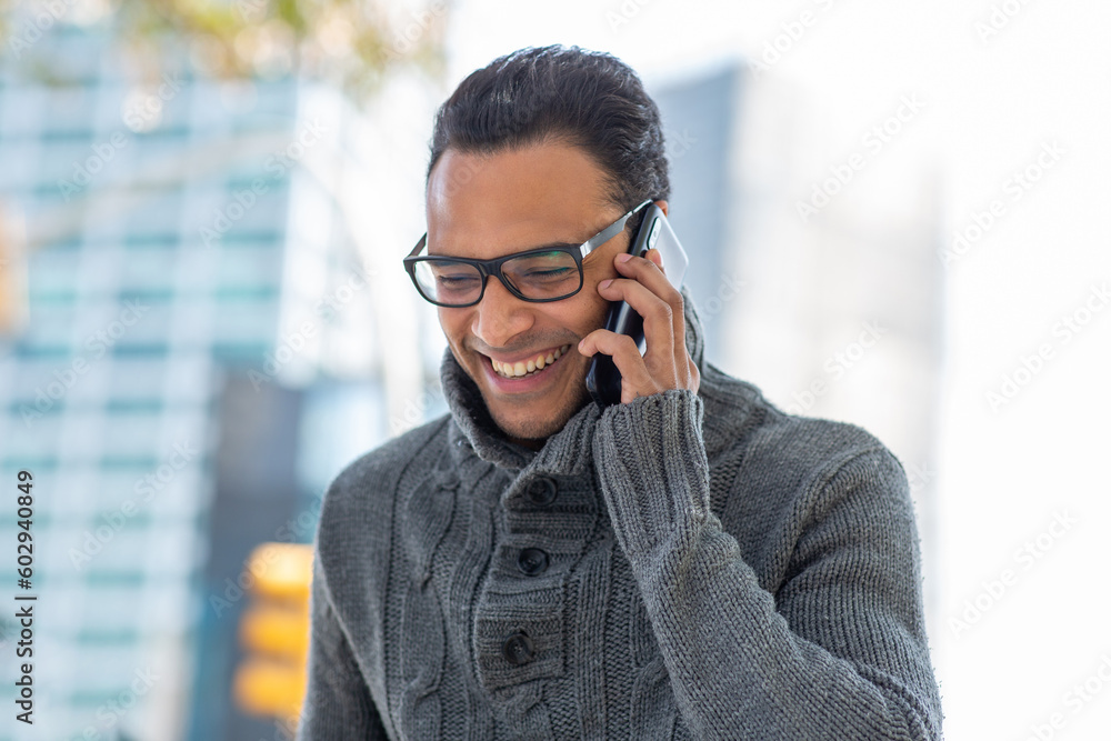 Smiling young african man with eyeglasses talking on cell phone outside Smiling young african man with eyeglasses talking on cell phone outside