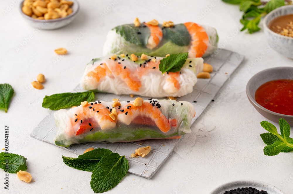 Summer rolls with fresh vegetables and shrimps and peanut sauce. Vietnamese appetizer. Salad spring rolls with prawns. Healthy food concept Summer rolls with fresh vegetables and shrimps and peanut sauce. Vietnamese appetizer. Salad spring rolls with prawns. Healthy food concept