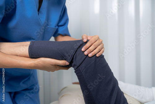 Female asian physiotherapist worker giving leg massage to senior woman, closeup. Rehabilitation physiotherapy in rehabilitation center, muscle weakness, Calf and knee pain