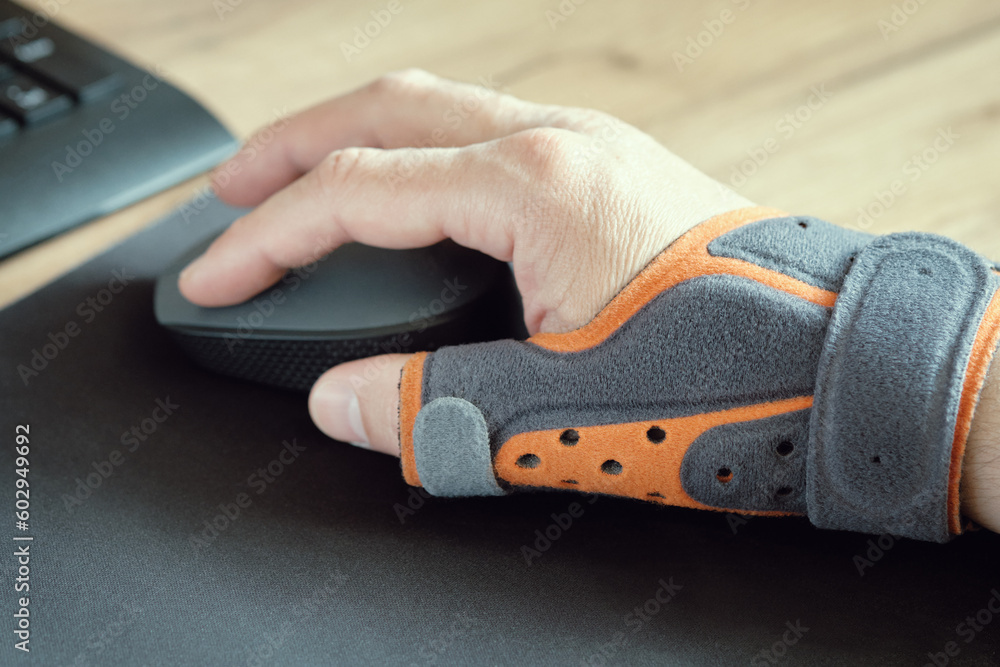 Male hand with a thumb brace. Fixing orthosis. Treatment of sprains