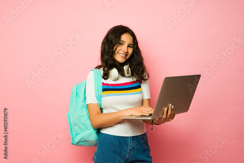 Obraz na plátně Beautiful teen girl using her laptop at junior high shcool