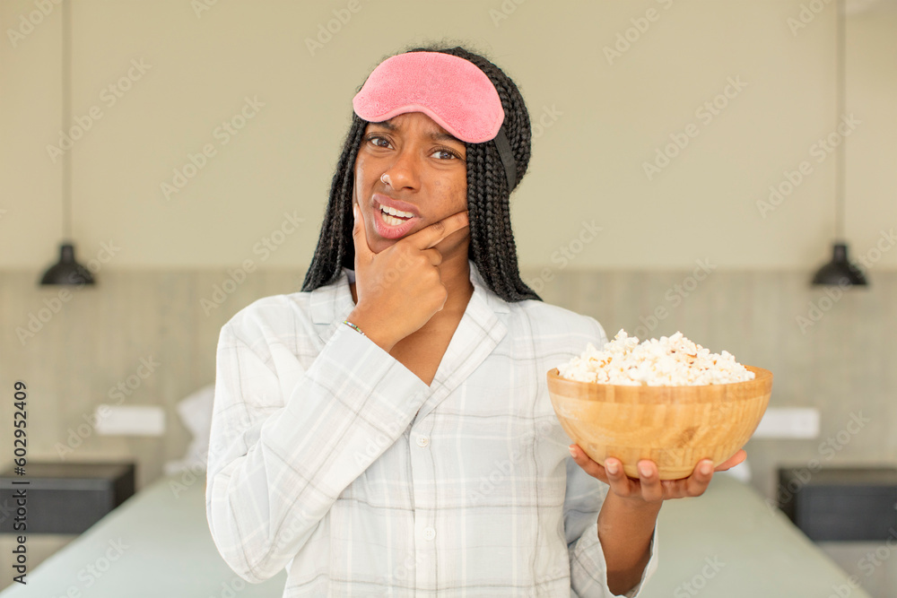 black afro woman with mouth and eyes wide open and hand on chin. rest and nightwear concept