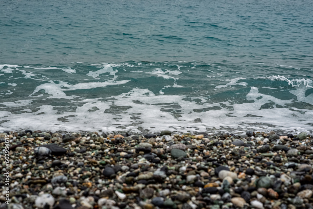 oceano de agua salada con olas, piedras y arena