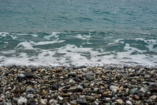 oceano de agua salada con olas, piedras y arena