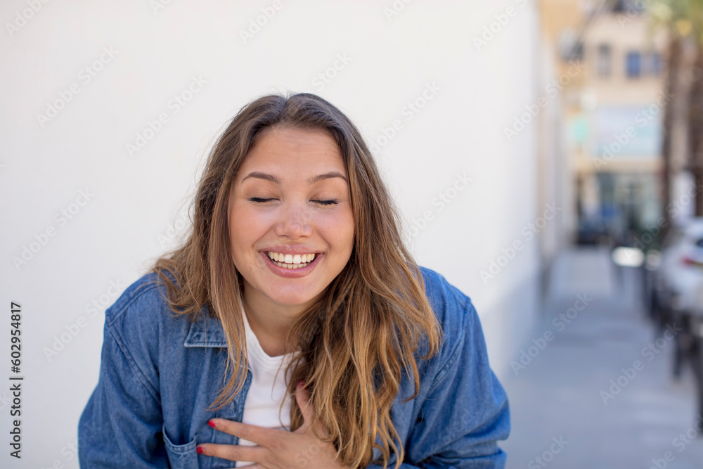 pretty hispanic woman laughing out loud at some hilarious joke, feeling happy and cheerful, having fun