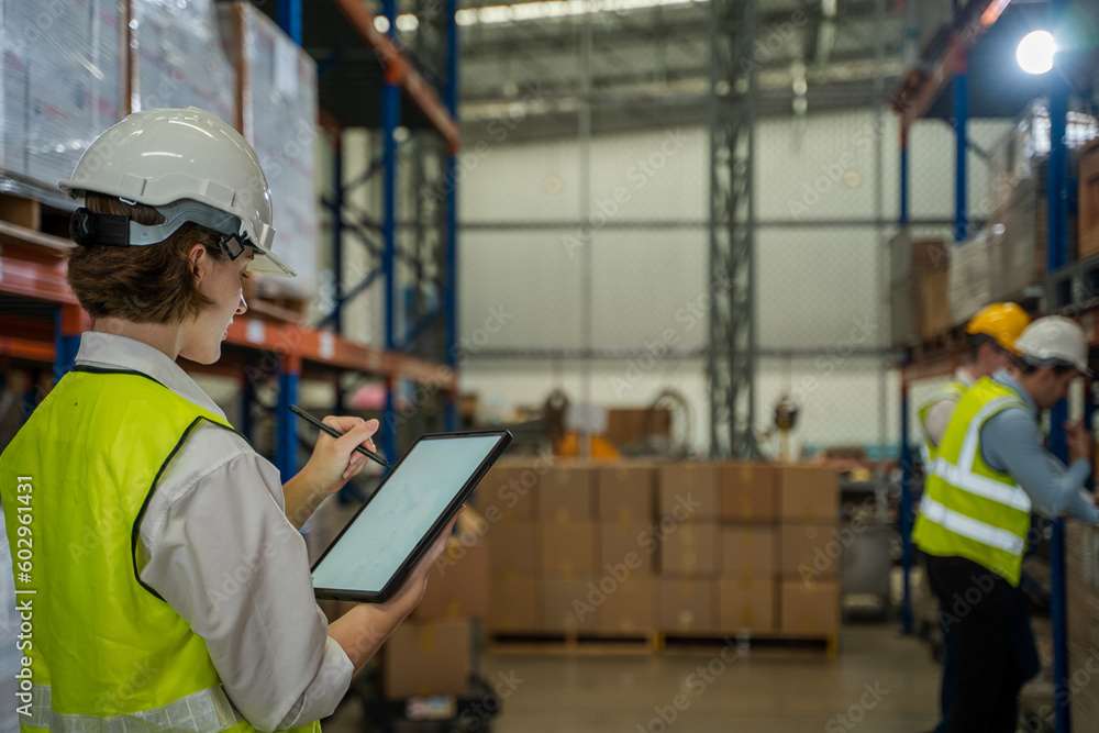Warehouse employees uses digital tablet computer with Inventory checking software in the retail warehouse full of shelves with goods,Distribution Center. Warehouse employees uses digital tablet computer with Inventory checking software in the retail warehouse full of shelves with goods,Distribution Center.