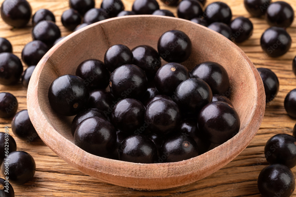 Jabuticabas on a bowl over wooden table Jabuticabas on a bowl over wooden table