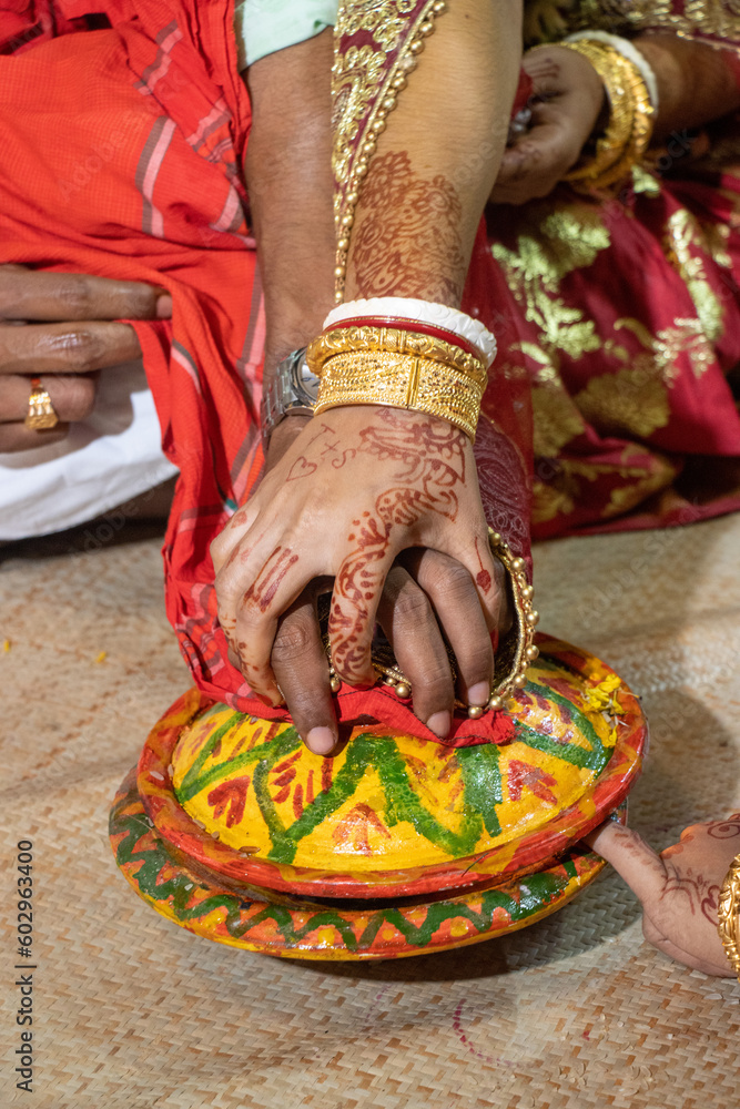 Traditional Hindu wedding rituals decoration close-up shot. Bride and groom holding hands on a decorated clay pot. Hinduism marriage ceremony ritual. Beautiful Hindu couple holding hands.