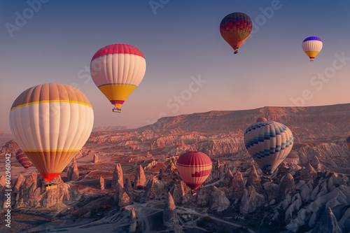 Landscape sunrise in Cappadocia with colorful hot air balloon fly in sky over deep canyons, valleys. Concept banner travel Goreme Turkey
