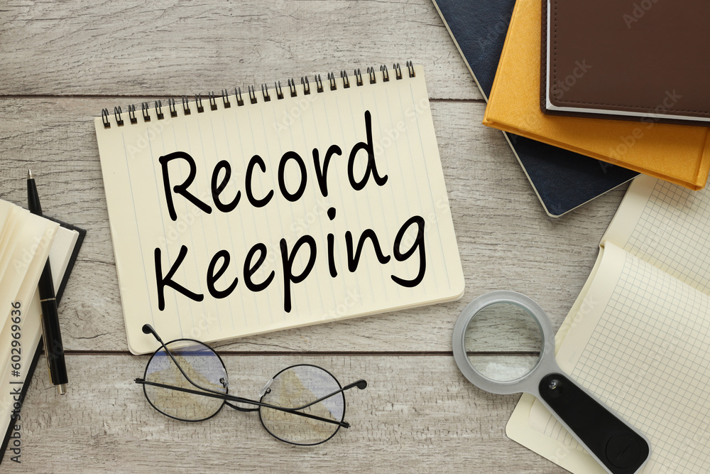 Fotografia record keeping notepad centered with text near magnifier and notepad