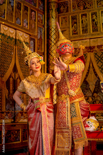 Photography Vertical image of beautiful Asian woman wear Thai traditional dress action of dancing together with Thai classic masked from the Ramakien character as red giant