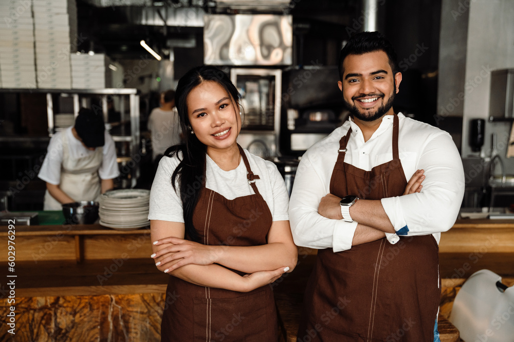 Obraz premium Friendly multinational business owners looking at camera in cafe