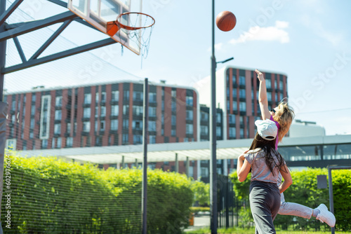 Mother and daughter playing basketball. © Angelov