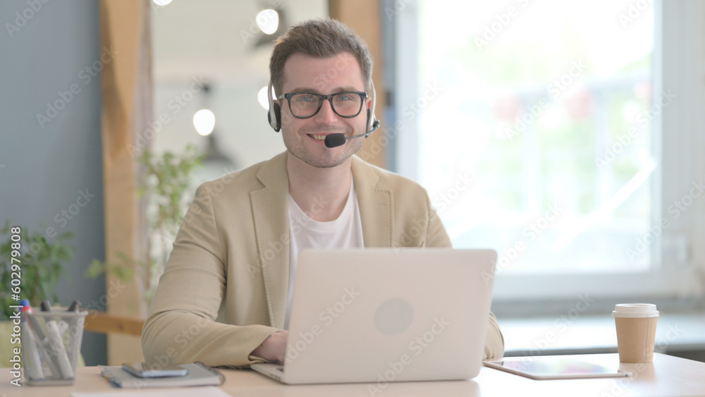Smiling Young Businessman with Headset in Call Center Smiling Young Businessman with Headset in Call Center