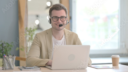 Smiling Young Businessman with Headset in Call Center