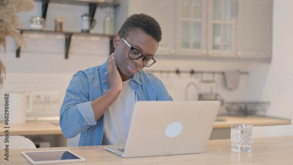 Young African Man with Neck Pain Working on Laptop Young African Man with Neck Pain Working on Laptop