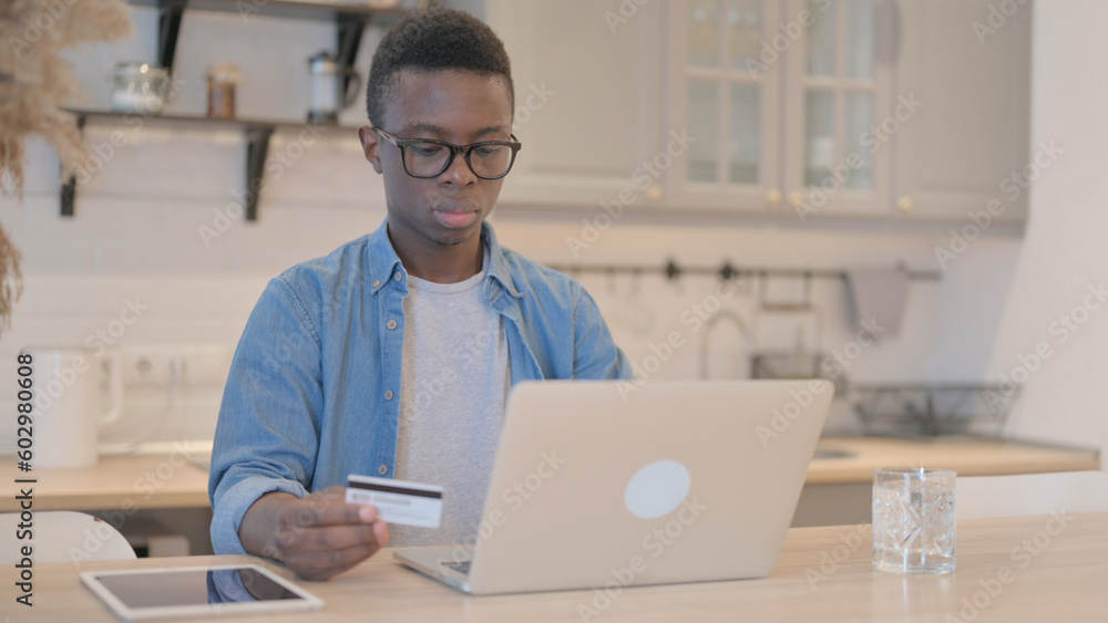 Successful Online Shopping by Young African Man on Laptop Successful Online Shopping by Young African Man on Laptop