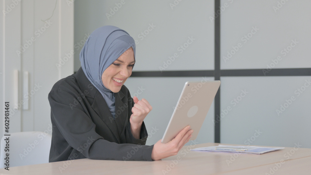 Muslim Businesswoman Celebrating Success on Tablet PC Muslim Businesswoman Celebrating Success on Tablet PC