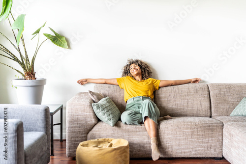 Happy afro american woman relaxing on the sofa at home - Smiling girl enjoying d Fototapeta