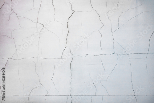 Small cracks on fresh painted plaster on a white wall  non-compliance with technologies in construction.