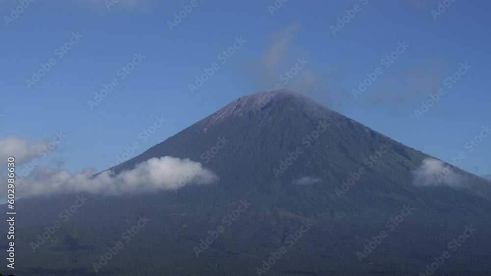 Mount Agung, Bali Indonesia The Mount Agung volcano with passing clouds and blue sky. Mount Agung, Bali Indonesia The Mount Agung volcano with passing clouds and blue sky.