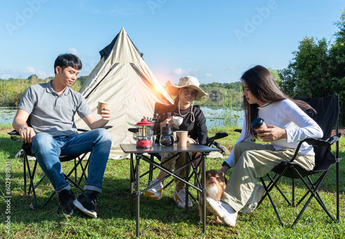 Young couple having a good time in the morning on a camping trip Couple enjoying camping with morning coffee