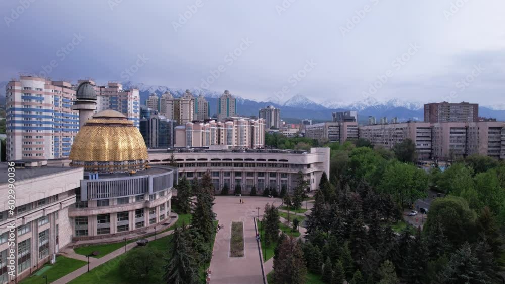 Almaty, Kazakhstan - May 2023: Palace of schoolchildren in Almaty city, Kazakhstan. Aerial footage of bright summer day cityscape with mountains and tv tower in the background. Almaty, Kazakhstan - May 2023: Palace of schoolchildren in Almaty city, Kazakhstan. Aerial footage of bright summer day cityscape with mountains and tv tower in the background.