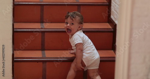 Baby crawling indoors going up home stairs
