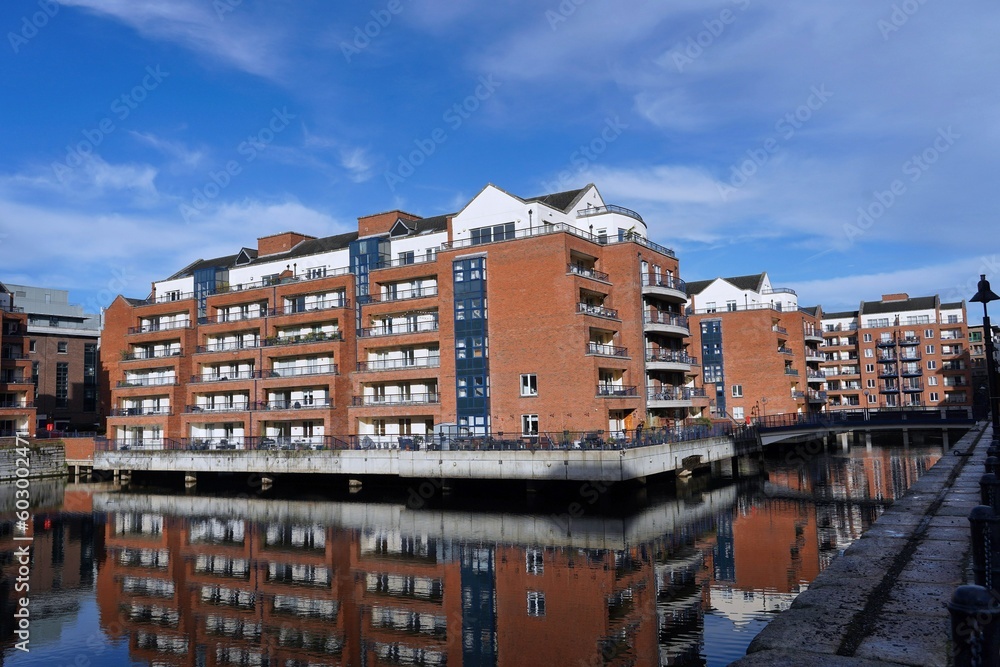 modern low-rise apartment buildings, redevelopment in a former industrial area, reflected in the still water of an old canal