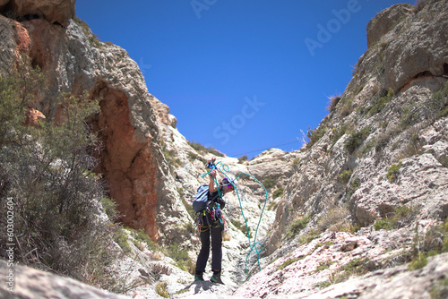 Sportsmen and women climb mountain through via ferrata in Villena, Spain. photo