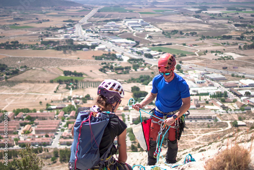 Sportsmen and women climb mountain through via ferrata in Villena, Spain. photo