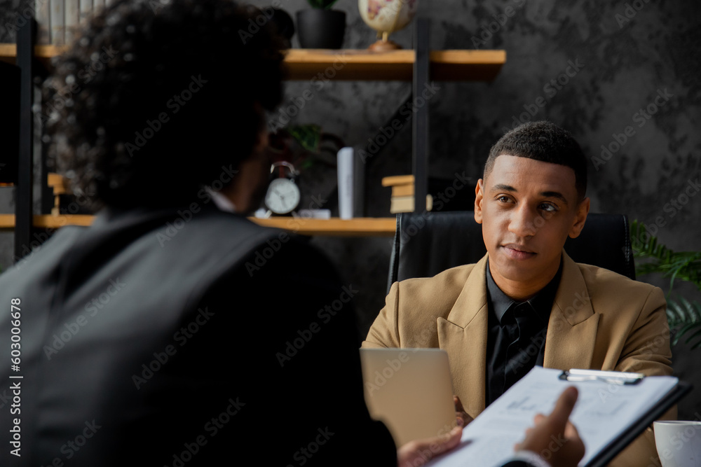 An employee of a financial company reports to the director on the profits and losses of the company. Men in business suits sit at a table and discuss documents. An employee of a financial company reports to the director on the profits and losses of the company. Men in business suits sit at a table and discuss documents.