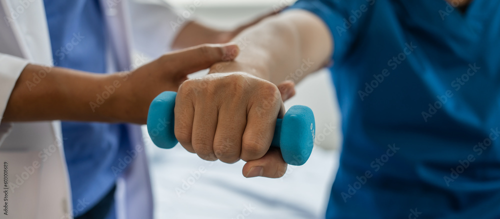 Using dumbbell, Physiotherapy specialists help patients in physiotherapy. about Muscle Weakness and Fatigue Using dumbbell, Physiotherapy specialists help patients in physiotherapy. about Muscle Weakness and Fatigue