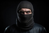 Mugshot of burglar wearing a balaclava closeup on black dark background. Portrait of thief burglar in a black hoodie and mask. Generative AI