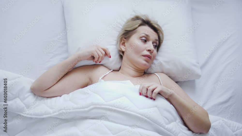 Irritated restless woman trying to wake up in morning, bad mood because of bad sleeping conditions, sleep deprivation due to uncomfortable posture and sleep apnea Irritated restless woman trying to wake up in morning, bad mood because of bad sleeping conditions, sleep deprivation due to uncomfortable posture and sleep apnea
