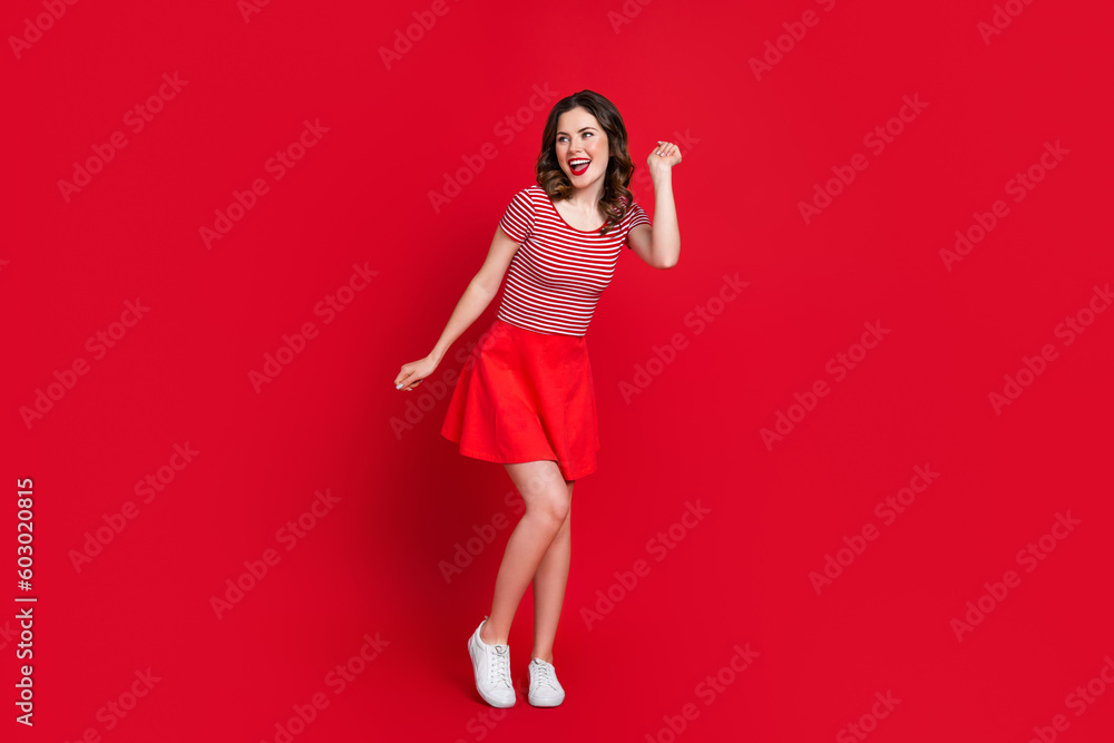 Full length photo of optimistic pretty lady have fun rejoice low prices clothes new collection empty space isolated on red color background Full length photo of optimistic pretty lady have fun rejoice low prices clothes new collection empty space isolated on red color background