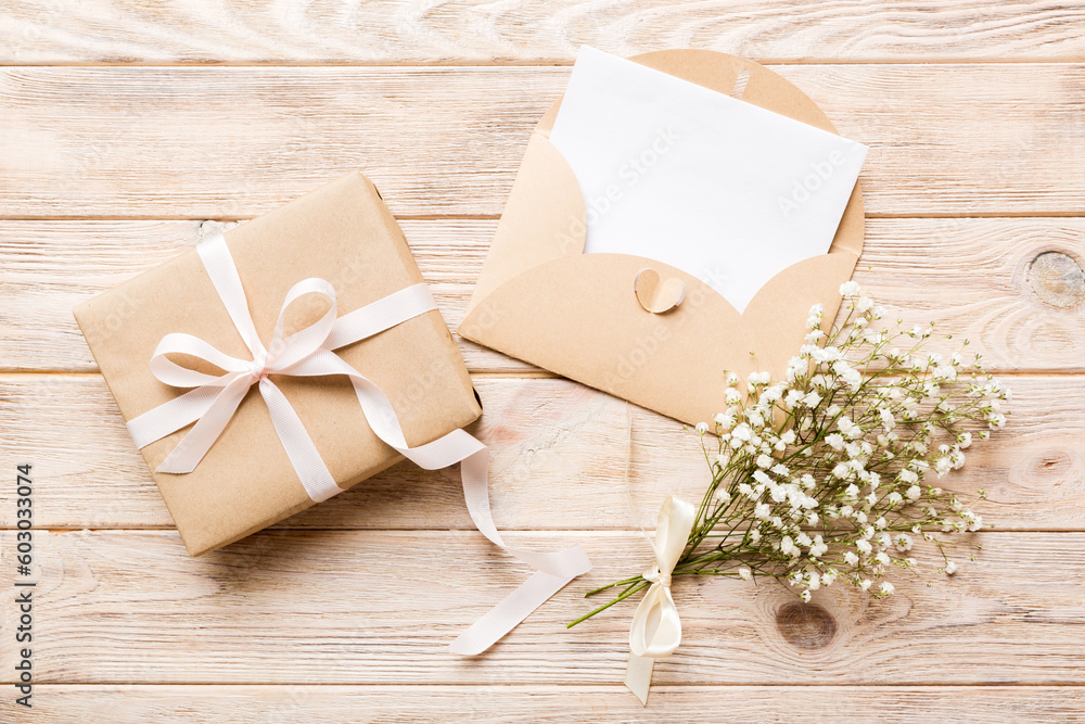 Wedding mockup with white paper list and flowers gypsophila on colored table top view flat lay. Blank greeting cards and envelopes. Beautiful floral pattern. Flat lay style Wedding mockup with white paper list and flowers gypsophila on colored table top view flat lay. Blank greeting cards and envelopes. Beautiful floral pattern. Flat lay style