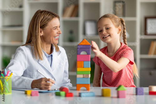 Fotobehang Child Development Specialist Looking At Little Girl Playing With Colorful Wooden