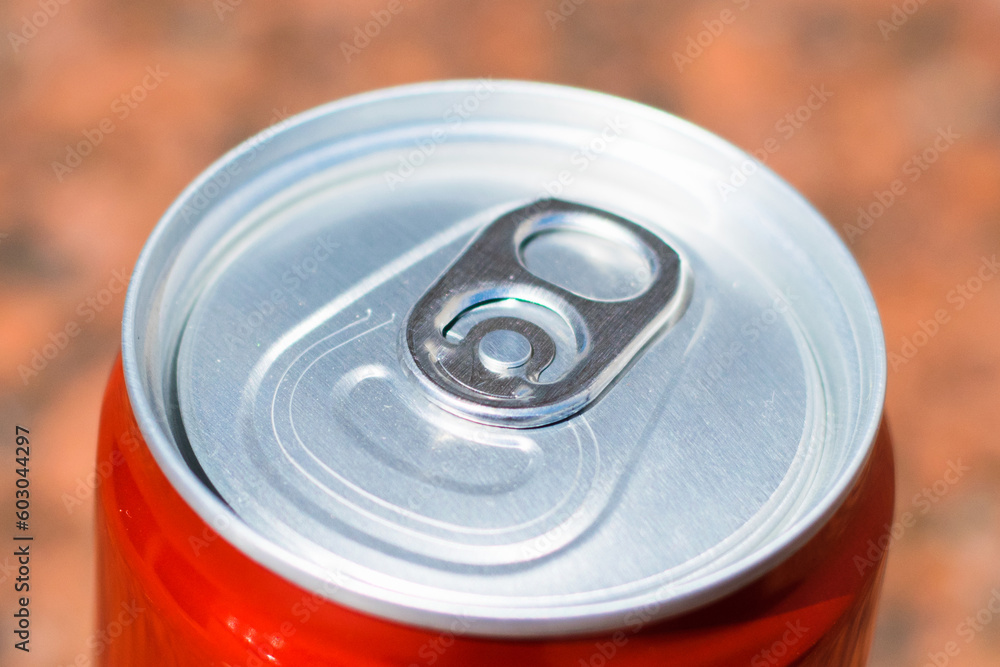Red tin can with drink on brown background Red tin can with drink on brown background