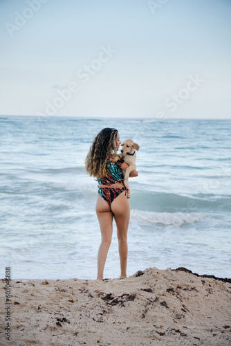 girl with her puppy in front of the beach