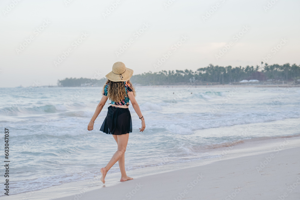 girl walking on the beach with her back turned