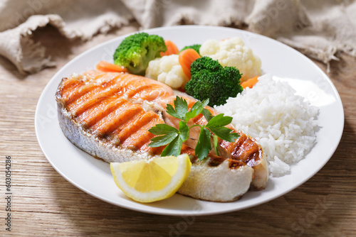 plate of grilled salmon steak, rice and vegetables