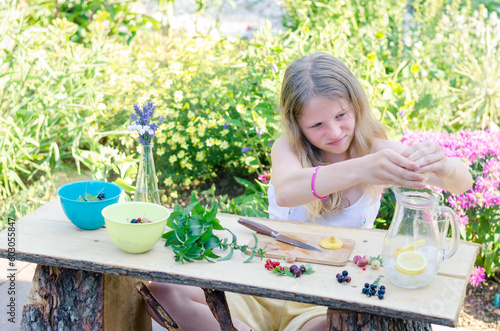 child preparing fresh juicy drink in colorful garden for the garden outdoor party