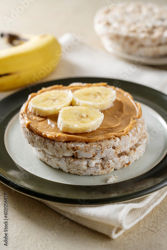 Rice cake with banana and peanut butter, healthy protein snack.
