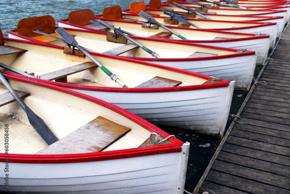 Row of docked wooden rowing boats for rent
